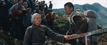 Movie still from “The Inn of the Sixth Happiness” (1958), directed by Mark Robson – An older woman and a young man in front of a group of people; Medium shot, Over the shoulder angle