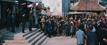 Movie still from “The Inn of the Sixth Happiness” (1958), directed by Mark Robson – A group of people standing on some steps in front of a building; Extreme Wide shot, High angle