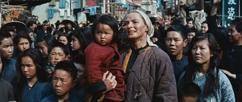 Movie still from “The Inn of the Sixth Happiness” (1958), directed by Mark Robson – An older woman holding a young child in her arms; Medium shot, Low angle