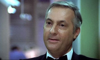 Movie still from “The Grilling” (1981), directed by Claude Miller – A person wearing a tuxedo; Close Up shot, Low angle