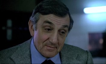 Movie still from “The Grilling” (1981), directed by Claude Miller – An older man wearing a suit and tie; Close Up shot, Low angle