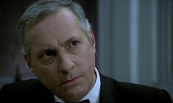 Movie still from “The Grilling” (1981), directed by Claude Miller – An older man in a suit and bow tie; Close Up shot, Low angle