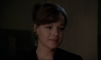 Movie still from “The Grilling” (1981), directed by Claude Miller – A person wearing a black jacket; Close Up shot, Over the shoulder angle