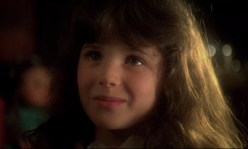 Movie still from “The Grilling” (1981), directed by Claude Miller – A young girl's face in a dark room; Close Up shot, Over the shoulder angle