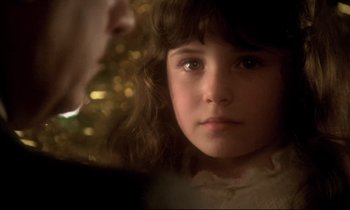 Movie still from “The Grilling” (1981), directed by Claude Miller – A young girl looking at the camera; Close Up shot, Over the shoulder angle