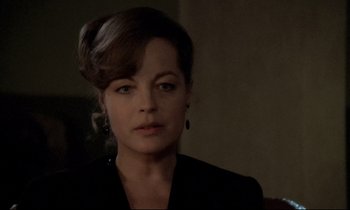 Movie still from “The Grilling” (1981), directed by Claude Miller – A person wearing a suit; Close Up shot, Over the shoulder angle