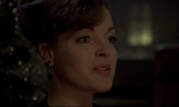 Movie still from “The Grilling” (1981), directed by Claude Miller – A person wearing a black shirt; Close Up shot, Over the shoulder angle