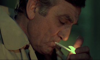 Movie still from “The Grilling” (1981), directed by Claude Miller – A person lighting a cigarette; Close Up shot, High angle
