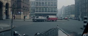 Movie still from “The Ipcress File” (1965), directed by Sidney J. Furie – Two cars are parked on the side of the road; Extreme Wide shot, High angle