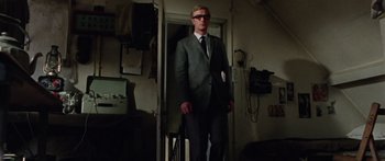 Movie still from “The Ipcress File” (1965), directed by Sidney J. Furie – A man in a suit standing in front of a door; Medium shot, Low angle