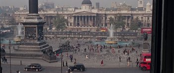 Movie still from “The Ipcress File” (1965), directed by Sidney J. Furie – An old photo of a fountain in the middle of a city; Extreme Wide shot, High angle