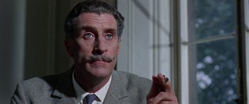 Movie still from “The Ipcress File” (1965), directed by Sidney J. Furie – A man that is holding a cigarette in his hand; Close Up shot, Low angle