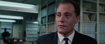 Movie still from “The Ipcress File” (1965), directed by Sidney J. Furie – A person wearing a suit and tie; Close Up shot, Low angle