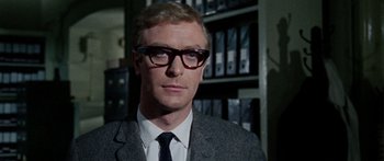 Movie still from “The Ipcress File” (1965), directed by Sidney J. Furie – A person wearing glasses and a suit; Close Up shot, Low angle