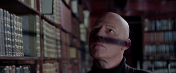 Movie still from “The Ipcress File” (1965), directed by Sidney J. Furie – A bald headed man looking up in a library; Close Up shot, Low angle