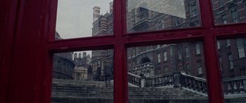 Movie still from “The Ipcress File” (1965), directed by Sidney J. Furie – People are walking on the steps in front of a large building; Extreme Wide shot, High angle