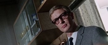 Movie still from “The Ipcress File” (1965), directed by Sidney J. Furie – A person wearing a suit and tie; Close Up shot, Low angle