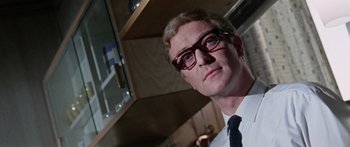 Movie still from “The Ipcress File” (1965), directed by Sidney J. Furie – A person wearing glasses and a tie; Close Up shot, Low angle