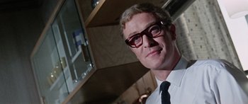 Movie still from “The Ipcress File” (1965), directed by Sidney J. Furie – A person wearing glasses and a tie; Close Up shot, Low angle