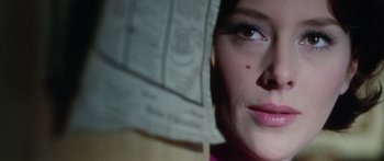 Movie still from “The Ipcress File” (1965), directed by Sidney J. Furie – A woman's face with a newspaper on her head; Close Up shot, Over the shoulder angle