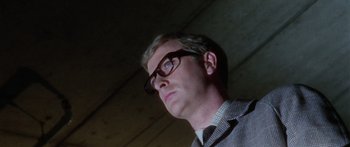 Movie still from “The Ipcress File” (1965), directed by Sidney J. Furie – A person wearing glasses looking up; Close Up shot, Low angle