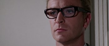 Movie still from “The Ipcress File” (1965), directed by Sidney J. Furie – A person wearing a pair of eyeglasses; Close Up shot, Over the shoulder angle