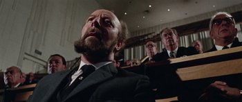 Movie still from “The Ipcress File” (1965), directed by Sidney J. Furie – A man with a beard and a suit and tie; Close Up shot, Low angle