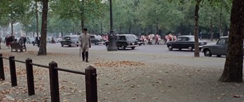 Movie still from “The Ipcress File” (1965), directed by Sidney J. Furie – A man walking on the sidewalk near a street; Extreme Wide shot, High angle