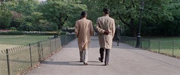 Movie still from “The Ipcress File” (1965), directed by Sidney J. Furie – A couple of men walking down a sidewalk; Wide shot, High angle