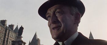 Movie still from “The Ipcress File” (1965), directed by Sidney J. Furie – An older man wearing a hat and a suit; Close Up shot, Low angle