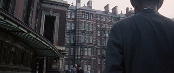 Movie still from “The Ipcress File” (1965), directed by Sidney J. Furie – A group of men standing next to each other on the street; Medium shot, Low angle