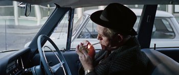 Movie still from “The Ipcress File” (1965), directed by Sidney J. Furie – An older man sitting in the back seat of a car; Medium shot, Over the shoulder angle