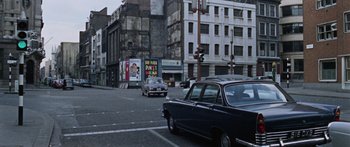 Movie still from “The Ipcress File” (1965), directed by Sidney J. Furie – Cars driving down a street in a city; Extreme Wide shot, High angle