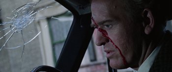 Movie still from “The Ipcress File” (1965), directed by Sidney J. Furie – A person in a car with blood all over his face; Close Up shot, Low angle