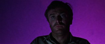 Movie still from “The Ipcress File” (1965), directed by Sidney J. Furie – A person in a purple room; Close Up shot, Low angle