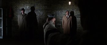 Movie still from “The Ipcress File” (1965), directed by Sidney J. Furie – A group of people standing in a dark room; Wide shot, Low angle