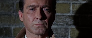 Movie still from “The Ipcress File” (1965), directed by Sidney J. Furie – A man's face in front of a brick wall; Close Up shot, Low angle