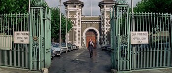 Movie still from “The Italian Job” (1969), directed by Peter Collinson – A man walking down a street in front of a building; Extreme Wide shot, Low angle