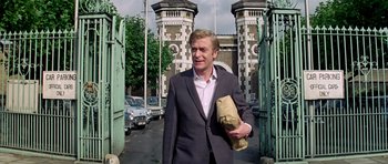 Movie still from “The Italian Job” (1969), directed by Peter Collinson – A man in a suit holding a bag walking down a street; Medium shot, Low angle
