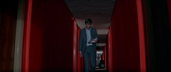 Movie still from “The Italian Job” (1969), directed by Peter Collinson – A man in a suit is walking down a hallway; Wide shot, Low angle