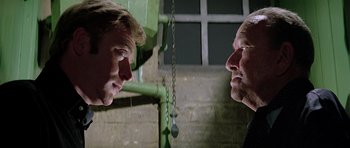 Movie still from “The Italian Job” (1969), directed by Peter Collinson – Two men are looking at each other in the mirror; Close Up shot, Low angle