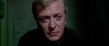 Movie still from “The Italian Job” (1969), directed by Peter Collinson – A person wearing a suit and tie; Close Up shot, Low angle