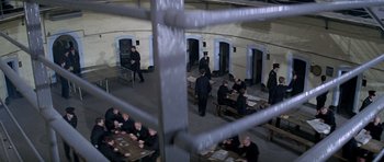 Movie still from “The Italian Job” (1969), directed by Peter Collinson – A group of men standing around a table; Extreme Wide shot, High angle