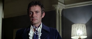 Movie still from “The Italian Job” (1969), directed by Peter Collinson – A person wearing a suit and tie; Close Up shot, Low angle