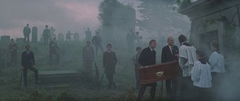 Movie still from “The Italian Job” (1969), directed by Peter Collinson – A group of men in suits standing in a field; Wide shot, Low angle