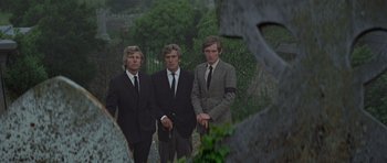 Movie still from “The Italian Job” (1969), directed by Peter Collinson – A group of men standing next to each other in suits; Medium shot, Low angle
