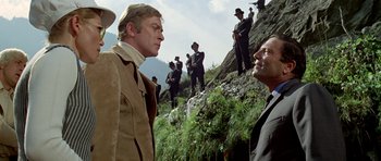 Movie still from “The Italian Job” (1969), directed by Peter Collinson – A group of men standing on top of a hill; Medium shot, Low angle