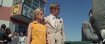 Movie still from “The Italian Job” (1969), directed by Peter Collinson – A man and a woman standing next to each other; Medium shot, Low angle