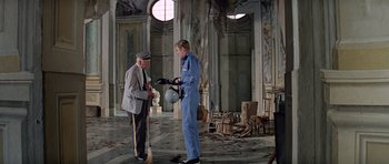 Movie still from “The Italian Job” (1969), directed by Peter Collinson – Two men are standing in an abandoned building; Wide shot, Low angle