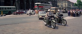 Movie still from “The Italian Job” (1969), directed by Peter Collinson – A group of people on motorcycles on a city street; Wide shot, High angle